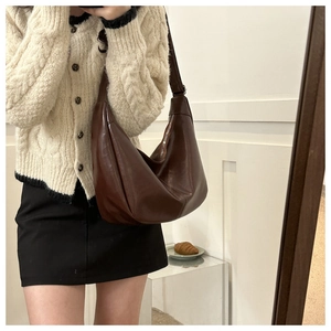 Détail du sac hobo en cuir marron foncé avec large bandoulière et fermeture éclair