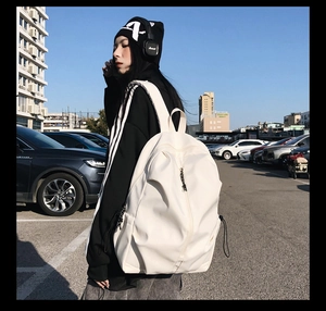Outdoor view of a white waterproof nylon minimalist backpack with decorative drawstring