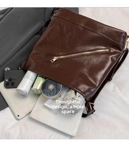 Flat lay of large dark brown tote bag showing spacious interior with tablet and accessories