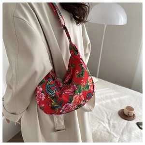 Close-up of red ethnic floral canvas hobo bag with traditional peony and phoenix patterns