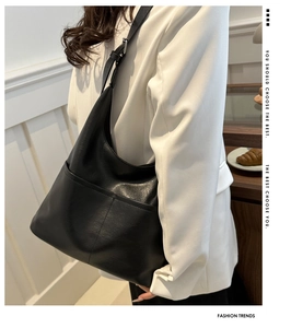 Close-up of black leather hobo tote bag featuring exterior pockets and silver hardware