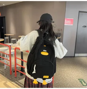 Detail of cute black corduroy duck backpack worn by a model in a cafe setting