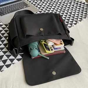 Japanese style minimalist black messenger bag showing large capacity and internal storage