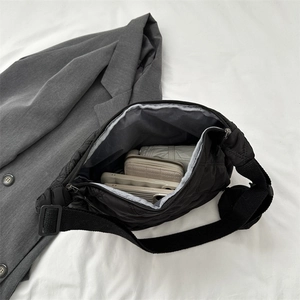 Detail view of the spacious interior of a black quilted crossbody bag showing storage capacity
