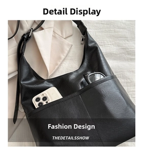 Close-up of black lychee leather hobo bag with dual functional front pockets for phone and glasses