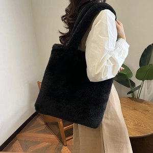 Detailed view of plush black tote bag showing soft faux fur texture and large capacity