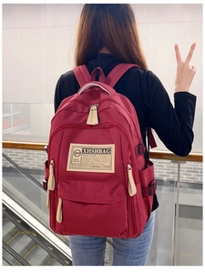 Dettaglio dello zaino in nylon bordeaux con tiranti in pelle e spallacci imbottiti