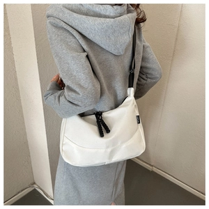 Detail view of white canvas sports bag with adjustable nylon strap and SPORT side label