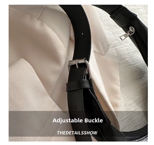 Detail of adjustable black leather shoulder strap with silver buckle on tote bag