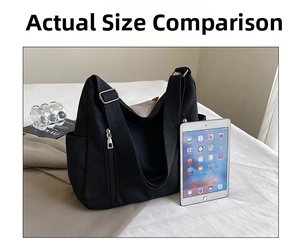 Size comparison of large black canvas tote bag next to a tablet for scale