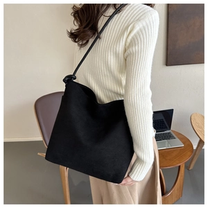 Detailed view of black matte bucket bag with stylish knotted shoulder strap for daily commuting