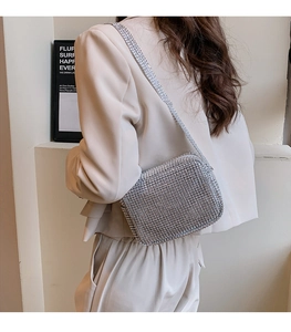 Close-up of sparkling silver rhinestone crossbody bag with matching jeweled strap details