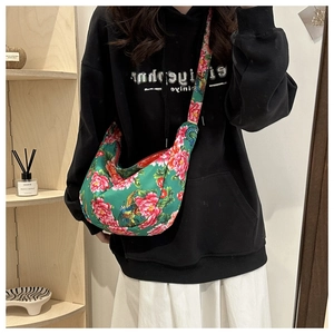 Detailed view of green canvas hobo bag with traditional Chinese floral and phoenix patterns