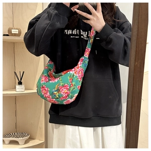 Détail du sac croissant en toile verte avec broderies de fleurs et phénix éclatantes