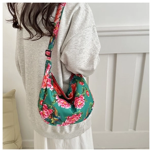 Detail of green hobo bag with traditional Chinese peony and phoenix prints and red zipper