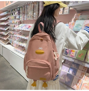 Detailed texture of pink corduroy material on a cute cartoon duck backpack with duck feet