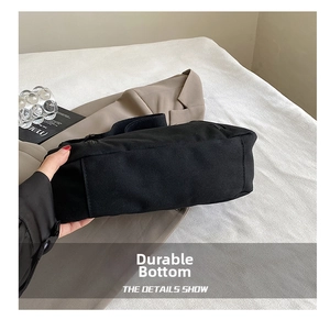 Detailed macro view of the durable wear-resistant base of the black canvas tote bag