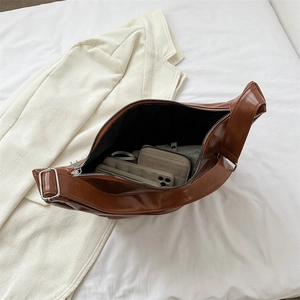 Sac demi-lune marron de grande capacité montrant l'espace intérieur pour portefeuille et mobile
