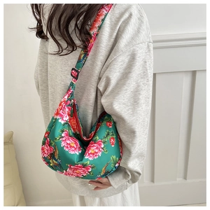 Detail of crescent canvas bag with traditional floral print and adjustable strap