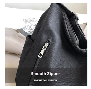Detail of smooth metal zipper and thick black canvas texture on a large tote bag