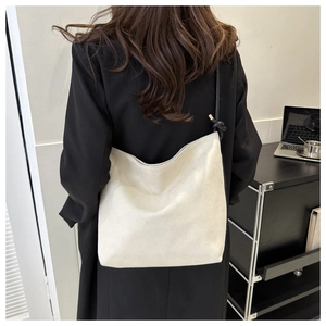 Minimalist creamy white matte tote bag shown on model in a modern office setting