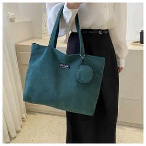 Detail of dark green corduroy tote bag with round coin purse and fashion instinct label