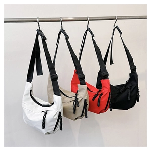 Detail view of colorful nylon crescent crossbody bags with adjustable buckle straps