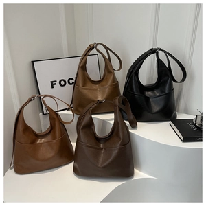 Detail view of large tote bags in black, caramel, coffee, and khaki textured PU leather