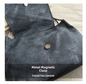 Detail of magnetic clasp closure and woven chain strap on dark gray canvas tote bag
