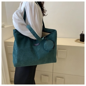 Close-up of deep green corduroy tote bag with round coin purse and side-view model shot