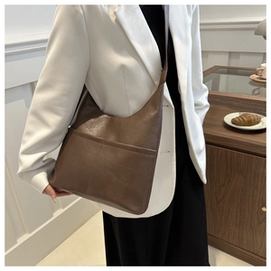 Detail of dark brown faux leather tote with textured surface and large front pocket