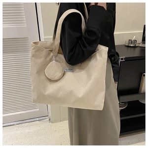 Detail of beige corduroy tote bag with Fashion Instinct label and round coin purse
