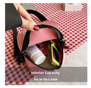 Detail view showing internal capacity of pink canvas shoulder bag with small items