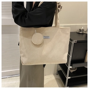 Detail of off-white corduroy tote bag with round coin purse and FASHION label
