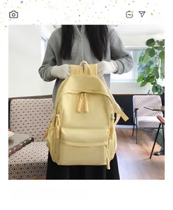 Détail d'un sac à dos en nylon jaune clair montrant la poche avant et les zips tissés