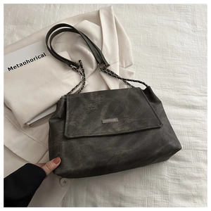 Detailed view of dark grey vintage texture tote with silver chain strap and metal logo