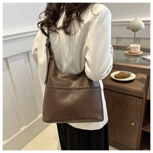 Detail view of large dark brown retro tote bag with dual front pockets and adjustable strap