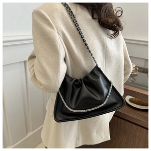 Detail of black pleated cloud bag with silver chain and leather woven shoulder strap