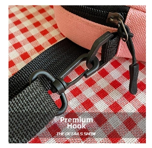 Detail of pink woven canvas bag showing durable black plastic swivel hook and nylon strap