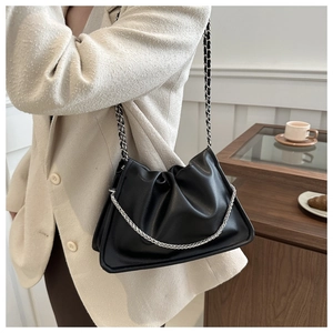 Détail du sac noir plissé avec bandoulière en chaîne et finition en cuir mat