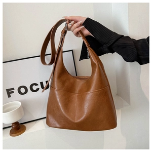 Detail of caramel brown tote bag showing retro faux leather texture and front pocket