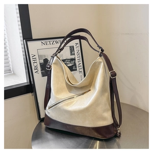 Close-up of dual-tone tote bag with side zipper and premium pebble leather texture