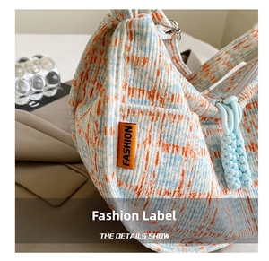 Close-up of blue and orange checkered corduroy bag texture with a Fashion label