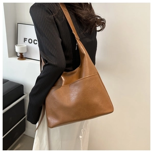 Detail of a large brown oil wax leather hobo tote bag with a practical front pocket