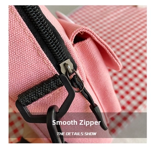 Detailed macro view of the smooth black zipper and durable pink canvas fabric on the bag