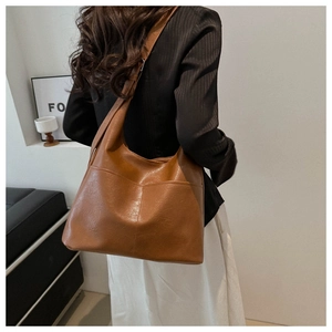 Detail of vintage brown tote bag with oily leather texture and functional front pockets