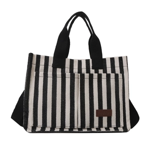 Striped canvas tote bag with black shoulder straps and double front exterior pockets