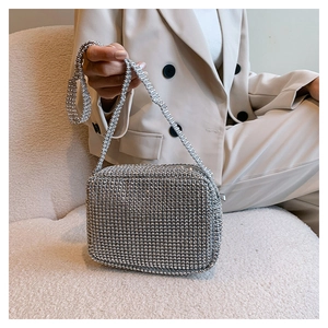 Detail of silver rhinestone evening bag with strap on a neutral background
