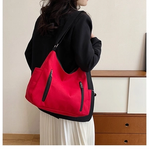 Large red canvas hobo tote bag for women with black decorative zippers and adjustable strap