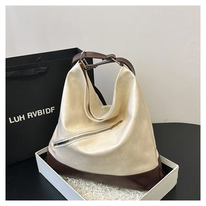 Detail of hobo bag with beige and brown contrast leather and metal zipper detail